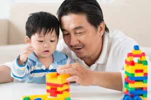 Father and son building with Legos