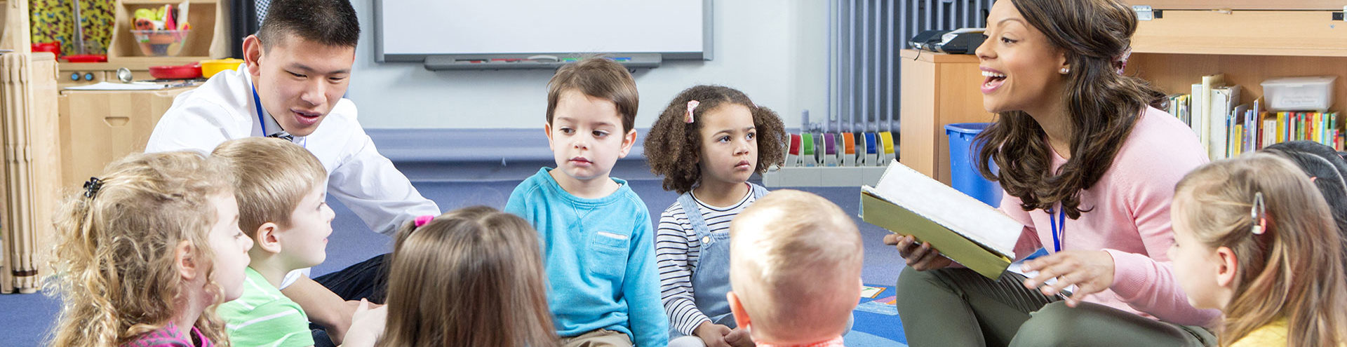 Male and female teachers reading to children