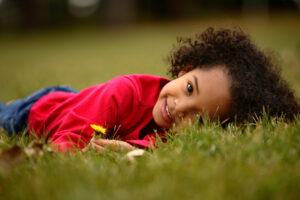 Child playfully laying in the grass