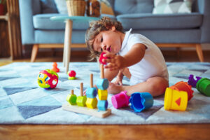 Beautiful toddler child girl playing with toys on the carpet