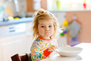 Adorable toddler girl eating a healthy breakfast