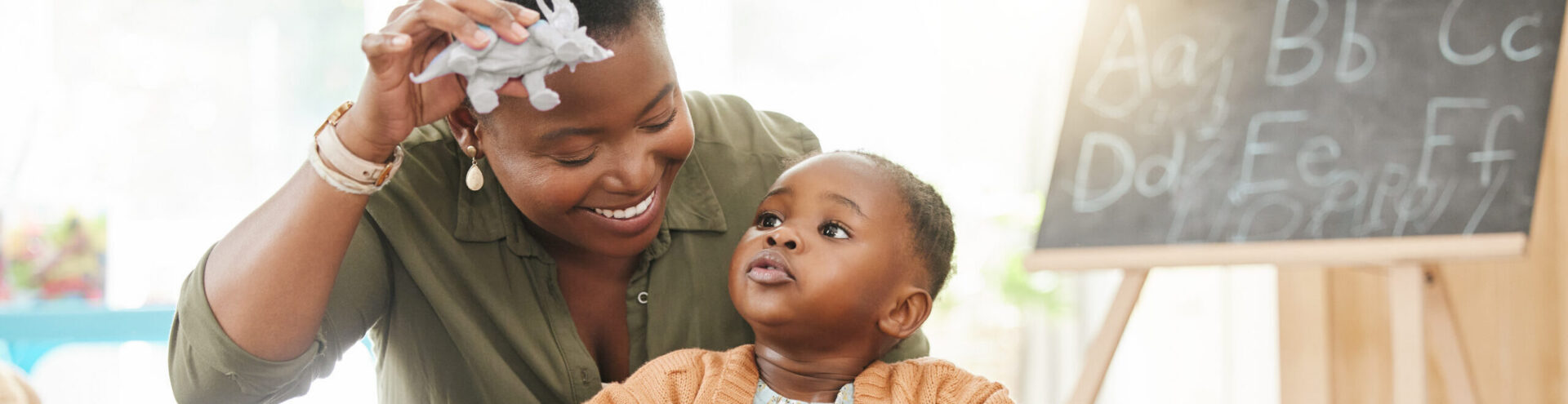 Mom, girl and happy with playing in home with toys for fun, education and child development. People, parent and smile with kid on floor for bonding with support, care and help for trust with love.